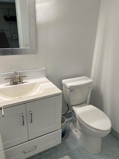 bathroom featuring tile patterned floors, vanity, and toilet