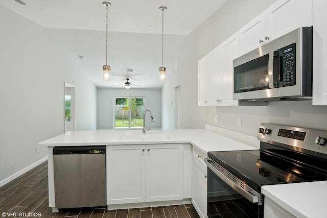 kitchen with appliances with stainless steel finishes, sink, kitchen peninsula, and lofted ceiling