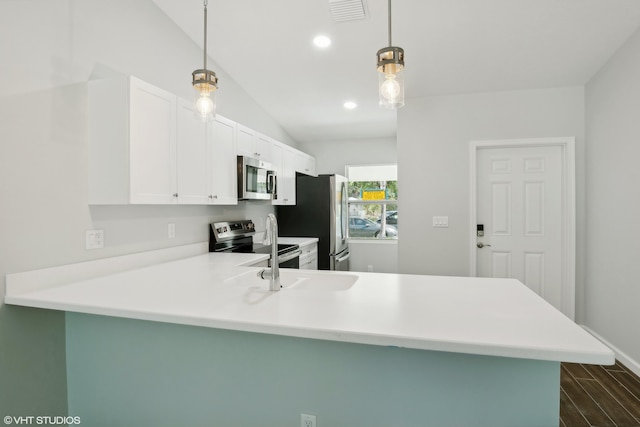 kitchen with decorative light fixtures, appliances with stainless steel finishes, dark wood-type flooring, vaulted ceiling, and kitchen peninsula