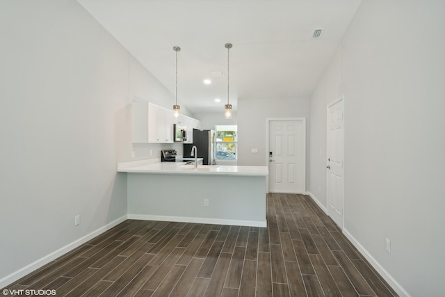 kitchen with kitchen peninsula, stainless steel fridge, lofted ceiling, and dark wood-type flooring