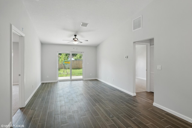 empty room featuring ceiling fan and dark carpet