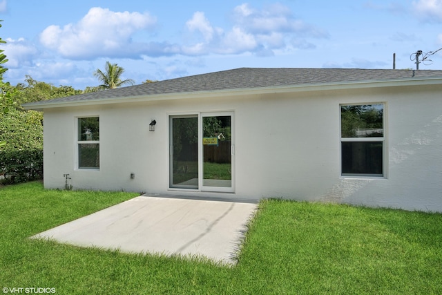 rear view of house with a lawn and a patio