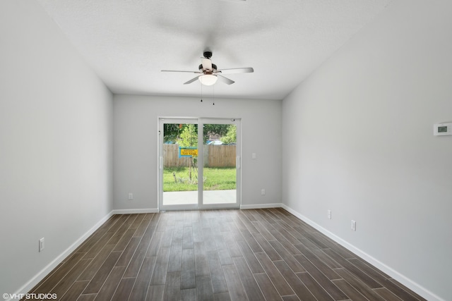 spare room featuring ceiling fan and dark wood-type flooring