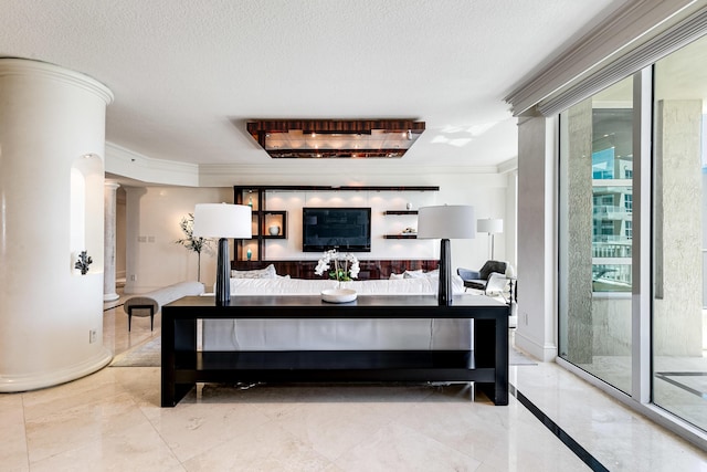 interior space with ornate columns, ornamental molding, marble finish floor, and a textured ceiling