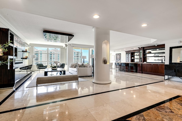 living area featuring decorative columns, baseboards, ornamental molding, marble finish floor, and recessed lighting