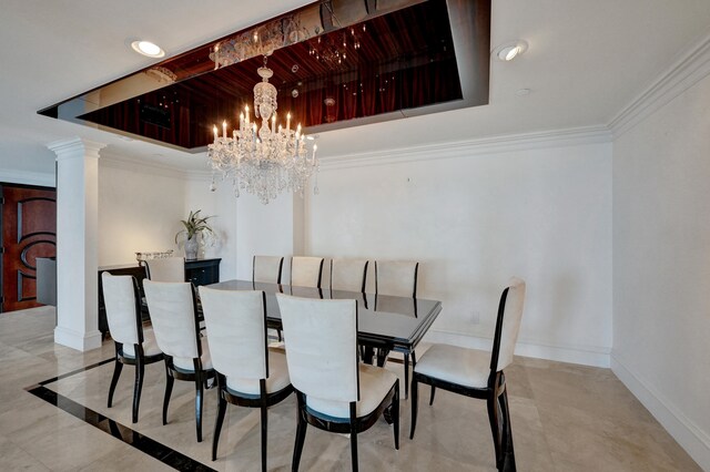 dining area with decorative columns, baseboards, ornamental molding, an inviting chandelier, and a tray ceiling