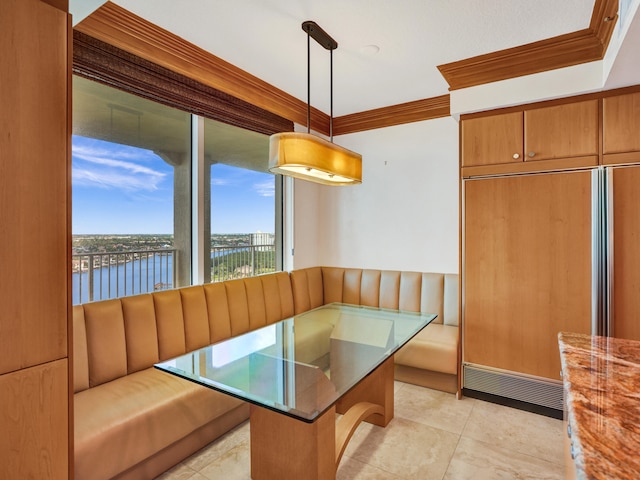 unfurnished dining area featuring light tile patterned floors, ornamental molding, and a water view