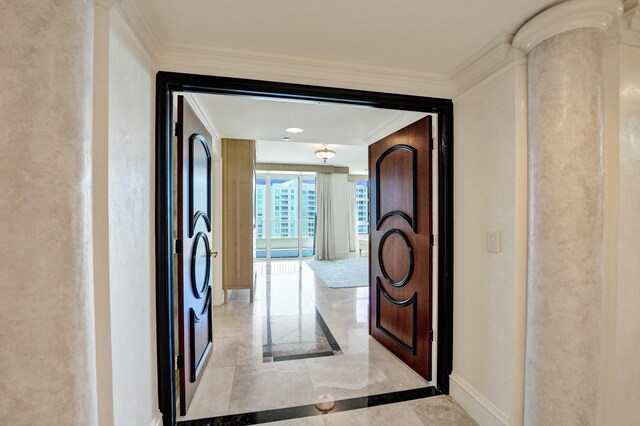 hallway featuring light tile patterned floors, decorative columns, and crown molding