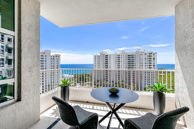 balcony featuring a water view and a city view