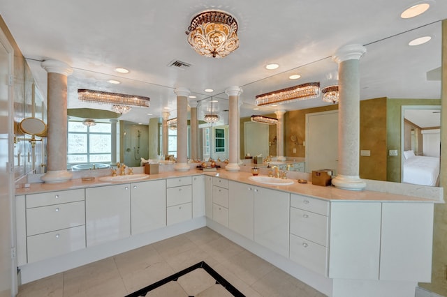 bathroom featuring tile patterned flooring, double vanity, and decorative columns