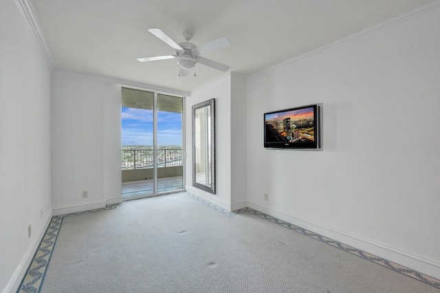 carpeted empty room featuring ceiling fan, crown molding, and a textured ceiling