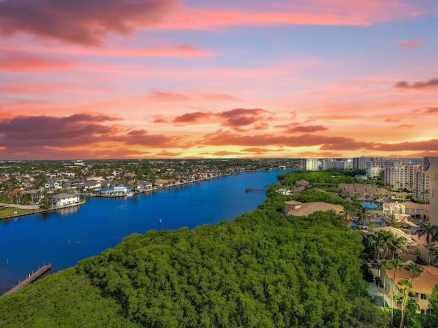 aerial view at dusk featuring a water view and a view of city