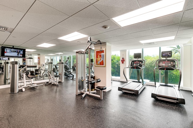 gym featuring a paneled ceiling, baseboards, and visible vents