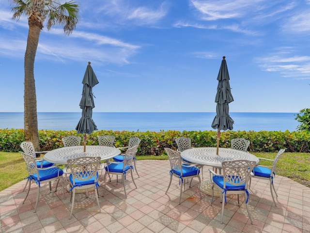 view of patio featuring a water view and outdoor dining space