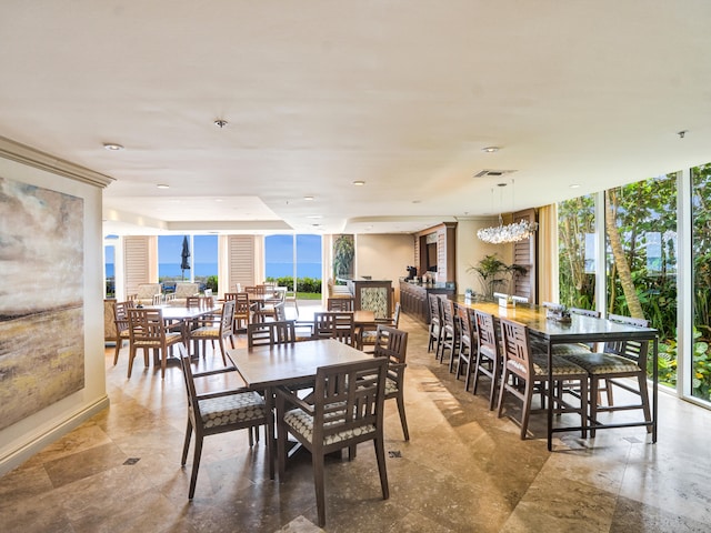 dining room featuring an inviting chandelier, a wall of windows, and light tile patterned flooring