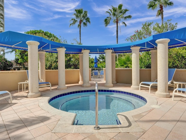 view of pool featuring a patio area, fence, and a hot tub