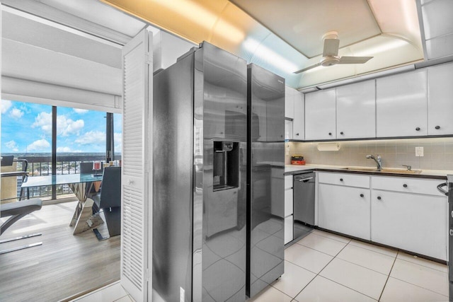 kitchen featuring decorative backsplash, light hardwood / wood-style flooring, ceiling fan, white cabinetry, and stainless steel appliances