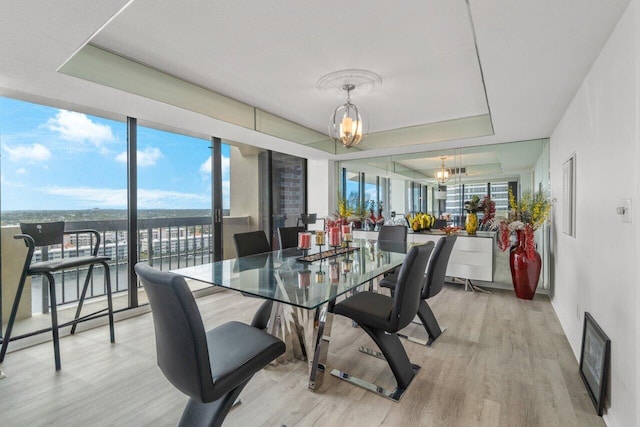 dining space featuring light wood-type flooring and an inviting chandelier