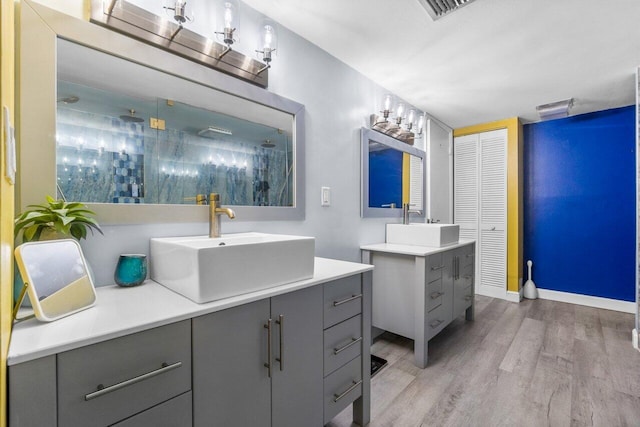 bathroom with wood-type flooring and dual vanity