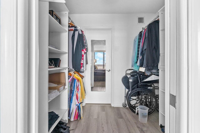 walk in closet with hardwood / wood-style floors