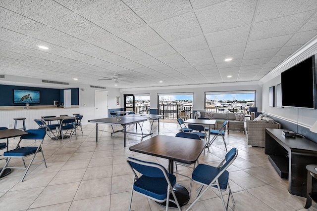 tiled dining area with a paneled ceiling and ceiling fan