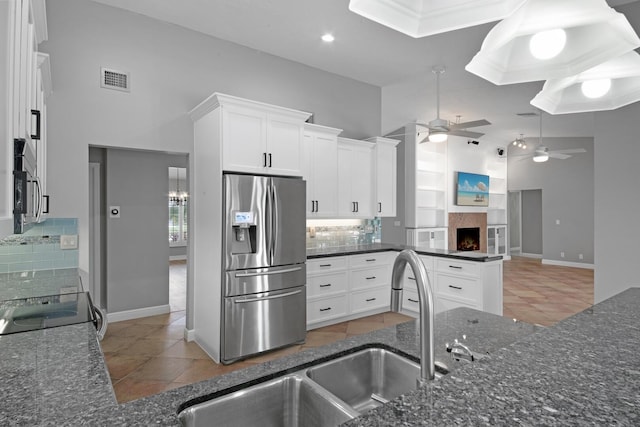 kitchen featuring ceiling fan, tasteful backsplash, tile patterned floors, and stainless steel refrigerator with ice dispenser