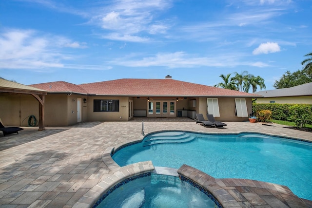 view of pool with a patio area and an in ground hot tub