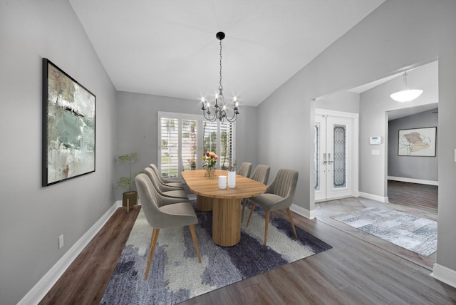 dining space featuring lofted ceiling, an inviting chandelier, and hardwood / wood-style flooring