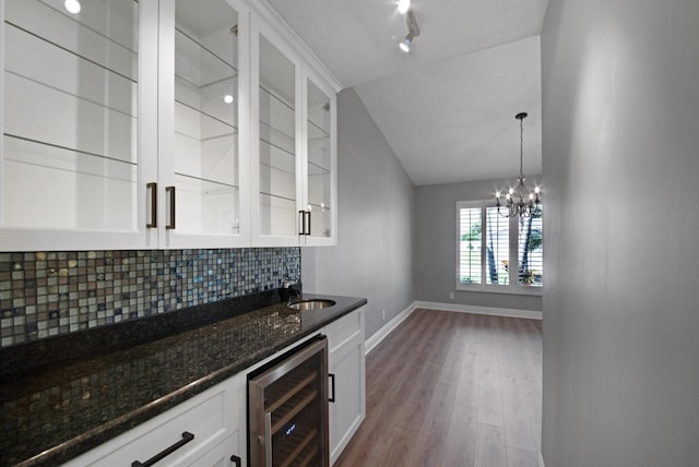 kitchen featuring light hardwood / wood-style flooring, tasteful backsplash, beverage cooler, hanging light fixtures, and white cabinets