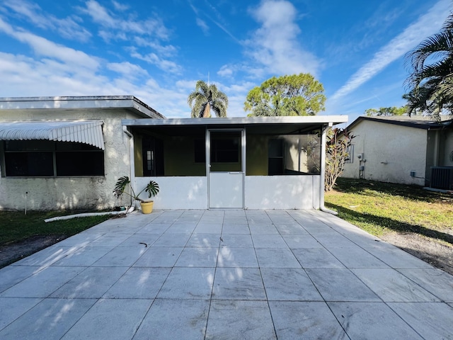 back of house with a lawn, cooling unit, and a sunroom