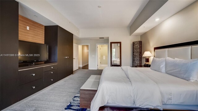 bedroom with ensuite bath and carpet floors