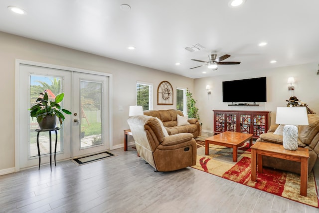 living room featuring a wealth of natural light, french doors, and light hardwood / wood-style floors