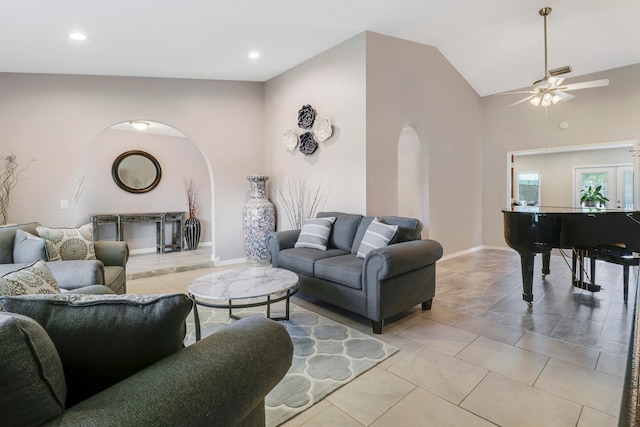 living room with ceiling fan, vaulted ceiling, and light tile patterned floors