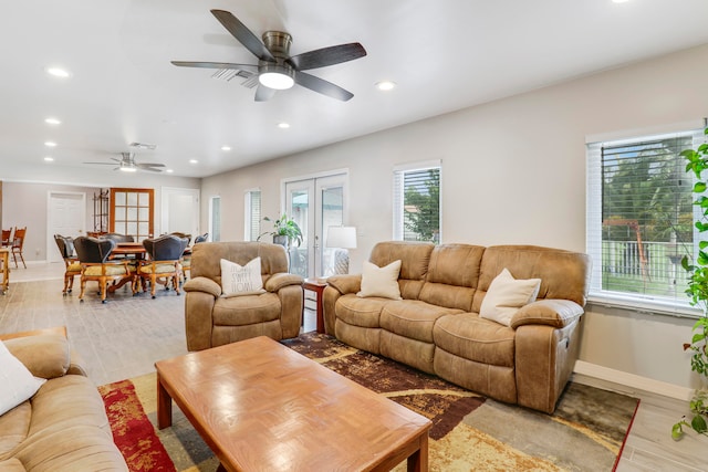 living room featuring ceiling fan, french doors, and light hardwood / wood-style flooring