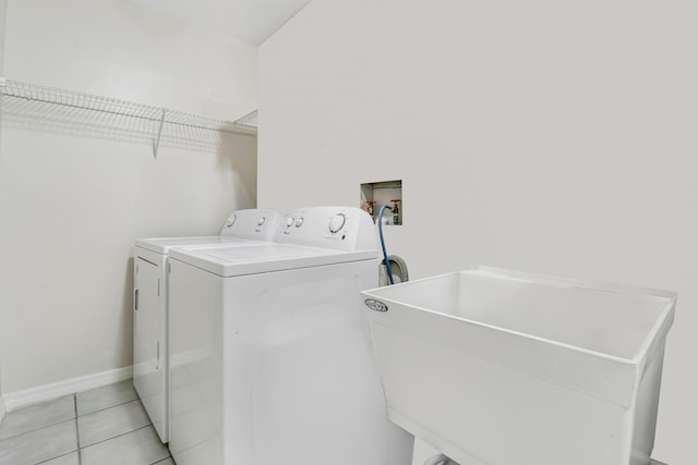 laundry room with light tile patterned flooring and washer and clothes dryer