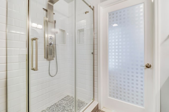 bathroom with a shower with door