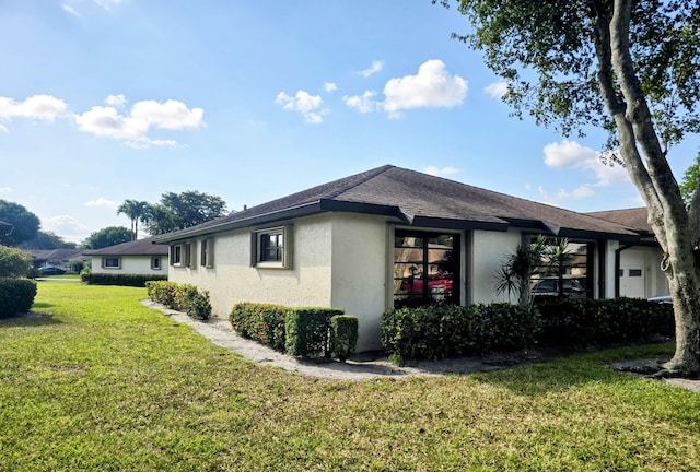 4908 Eaglewood Rd Unit A, Boynton Beach, FL 33436 - view of home's exterior with a yard, roof with shingles, and stucco siding