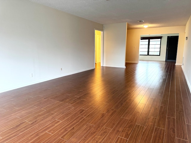 4908 Eaglewood Rd Unit A, Boynton Beach, FL 33436 - empty room featuring a textured ceiling, baseboards, and dark wood-style floors