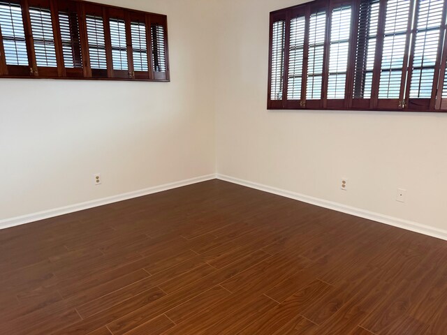 4908 Eaglewood Rd Unit A, Boynton Beach, FL 33436 - spare room featuring baseboards and dark wood-type flooring