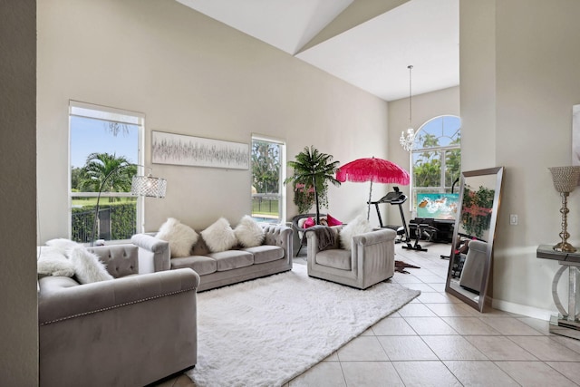 tiled living room featuring high vaulted ceiling and a notable chandelier