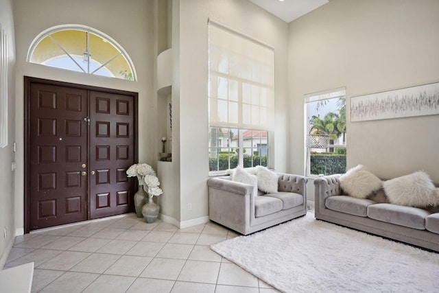 entryway featuring light tile patterned flooring and a high ceiling