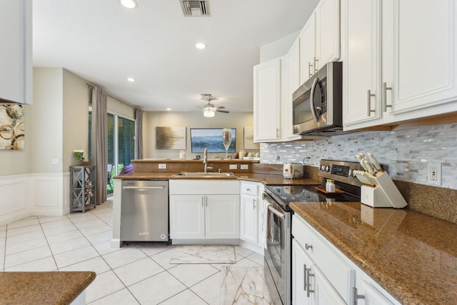 kitchen with sink, decorative backsplash, white cabinetry, and appliances with stainless steel finishes