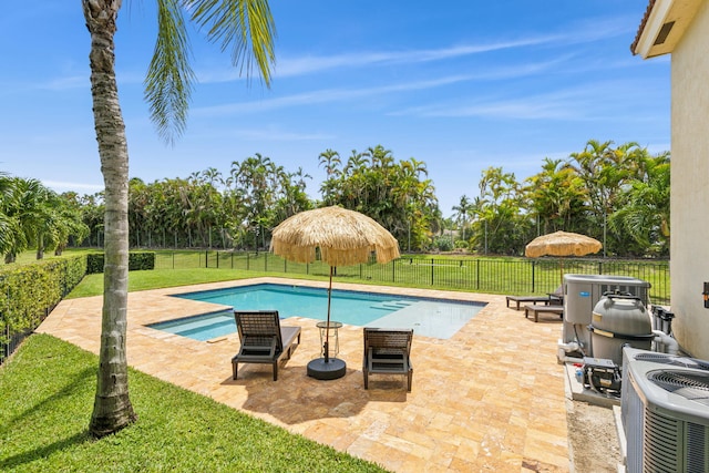 view of pool with a lawn, a patio area, and central air condition unit