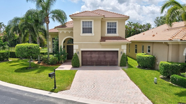 mediterranean / spanish home featuring a front lawn and a garage