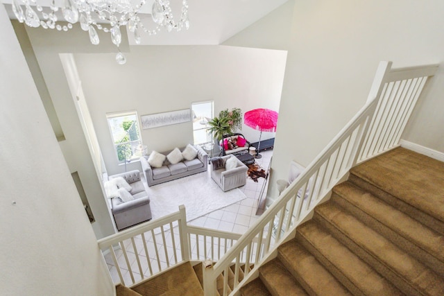 interior space featuring carpet floors, high vaulted ceiling, and an inviting chandelier