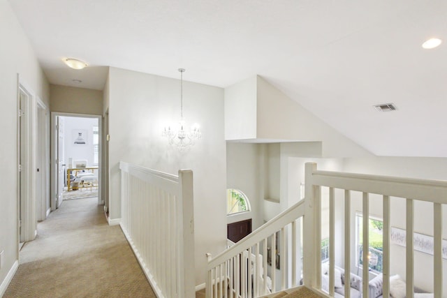 hall featuring a notable chandelier and light carpet