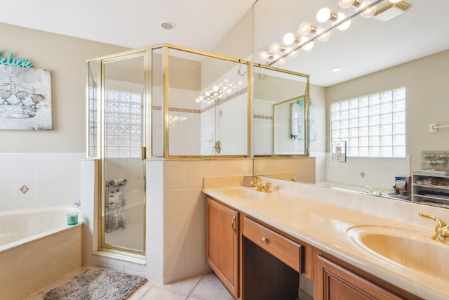 bathroom featuring shower with separate bathtub, double sink vanity, and tile patterned floors