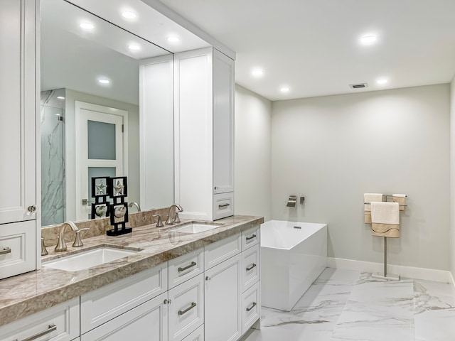 bathroom with a bathtub, dual bowl vanity, and tile patterned floors