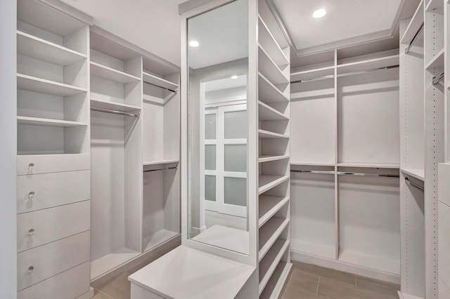 spacious closet with light tile patterned floors