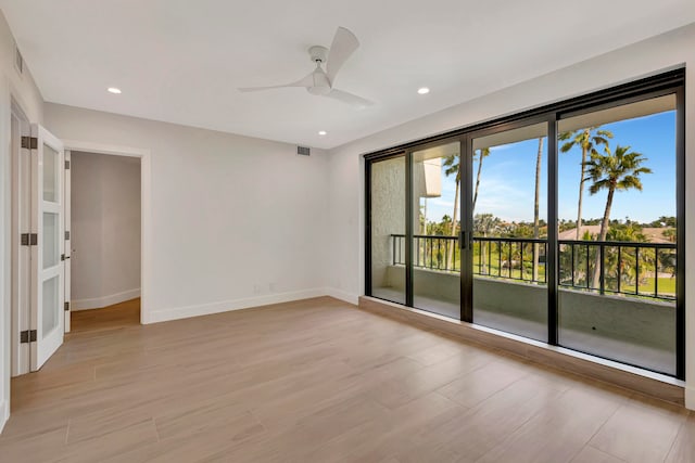 empty room with ceiling fan and light wood-type flooring